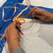 A close-up of hands using a clear curved measuring ruler with a pencil and tape measure on a white fabric layout over a blue cutting mat.
KEARING brand, No 8002, Clear Plastic Straight Ruler, 50cm x 5cm