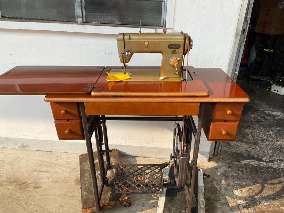 A vintage PFAFF sewing machine, Model 60, mounted on a wooden cabinet with drawers and a treadle base. Restoration completed by Sewing.sg.